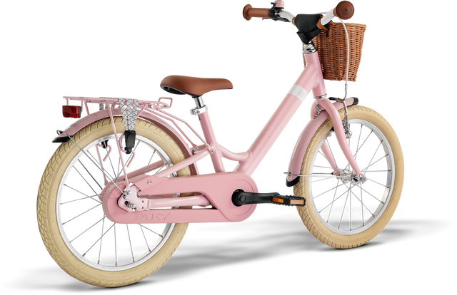 Den rosa Barncykeln - 18 Tum - 5 år - 1 Gear från märket PUKY, även känd som Youke 18 Classic, har krämfärgade däck, ett brunt säte och svart styre. Den är utrustad med en främre flätad korg, ett bakre lastställ och ett kedjeskydd. Designad med lättviktskomponenter för att säkerställa enkel hantering för unga ryttare.