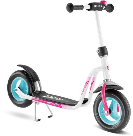 PUKY R 03 sparkcykel för barn från 3 år och uppåt har en vit ram, turkosa och svarta skumhjul, rosa accenter och svarta styrhandtag med "PUKY" inskrivet på dem. Däcket inkluderar en greppdyna märkt "AIR-LITE", och skotern är utrustad med ett stöd för balans.